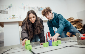 two teenagers with a VEX Robot arena