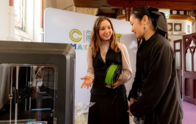 Two girls using the 3D printer