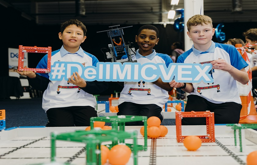 3 boys at VEX final holding a VEX and MIC sign