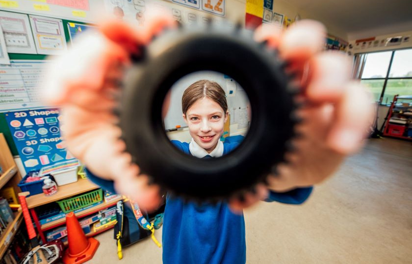 Girl looking through a tyre at CRAFT workshop