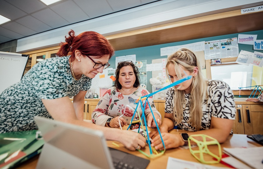 three ladies with a crane made of strawbees with a micro bit attached