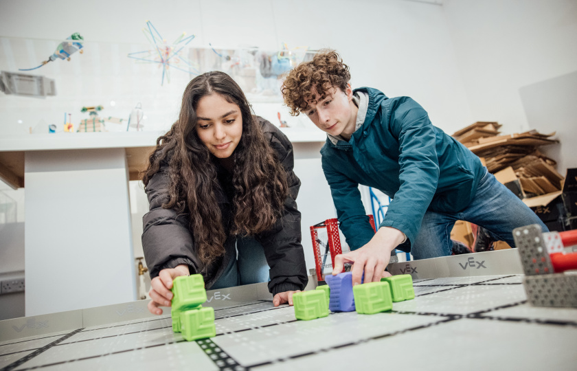 two teenagers with a VEX Robot arena